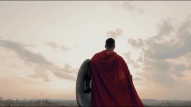 Kuru tarlada kaslı Spartalı, gün batımı.