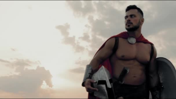 Shirtless spartan walking in field, sunset. — Stock Video