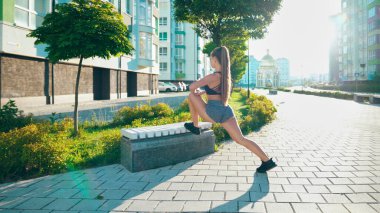 Baygın bir kadın. Bacağını dışardaki bankta esnetiyor..