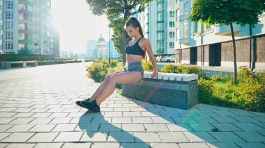 Kız trisepslerin üzerinde egzersiz yapıyor..