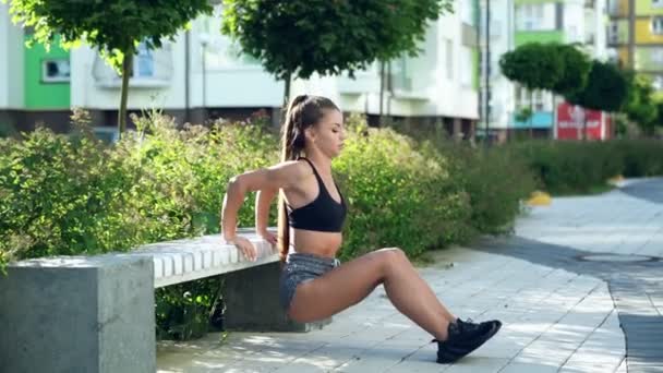 Женщина упражняется на трицепсах на скамейке. — стоковое видео