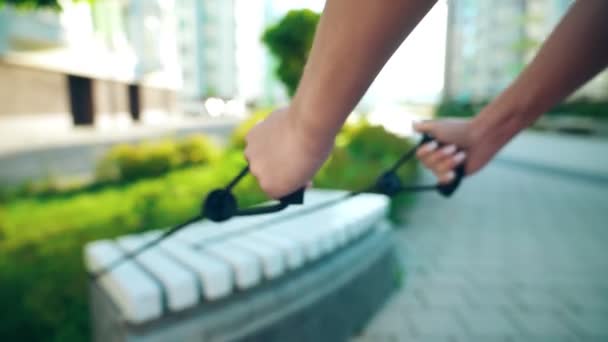 Unrecognizble woman using resistance band outdoors. — Stock Video