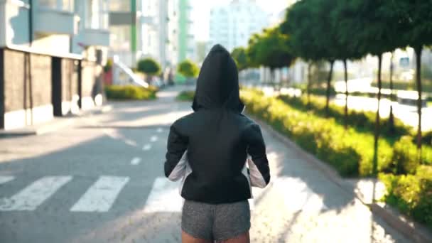 Nerozpoznatelná žena běží v ranním městě. — Stock video