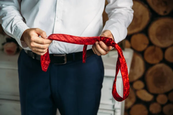 Empresário de close-up em camisa branca, noivo segurando gravata vermelha em suas mãos. Conceito de homens elegância elegante roupas . — Fotografia de Stock