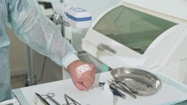 Närbild en läkare hand i ett sterilt kontor visar driften av en skanner för vener, medicinsk utrustning. Kirurgen gör manipulationer med instrument på sjukhuset. Behandling av — Stockvideo