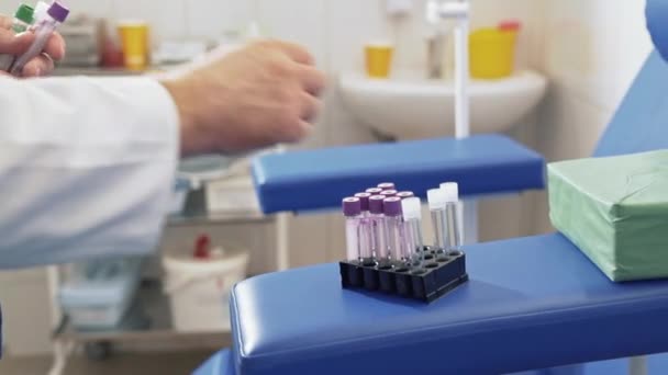 클로즈업 임상 실험실에서 의사 혈액 검사를 수행 하 고 테스트 튜브 용기에 넣습니다. 의료 장비와 병원에서 작동 하는 흰 멸 균 드레싱 가운에 외과 의사. — 비디오