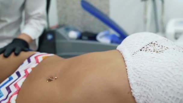 Una hermosa joven se encuentra en la silla de un cosmetólogo y se somete a un procedimiento de depilación láser. Medicina y cosmetología. Hermosa modelo en el cosmético, depilación . — Vídeos de Stock