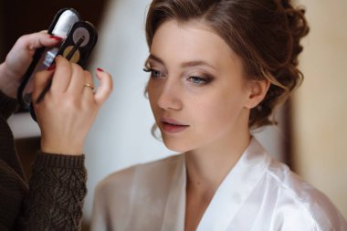 Yakın çekim çekim süreci makyaj sanatçısı gölgeler ile çalışır. Model yüzünde makyaj uzmanı geçerlidir.