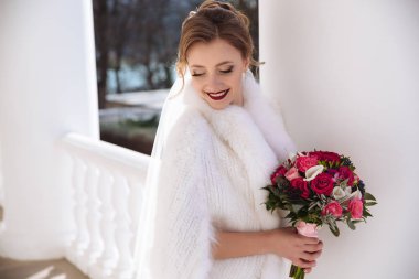 Bir beyaz kürk pelerin içinde gülümseyen bir gelin parlak koridorun yürüyor. Evlenen genç bir kız portresi. Gelin makyaj.