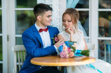 Yeni evliler terasta masada oturuyor. Adam heyecanla kız onun planları hakkında kız dikkatle ve düşünceli damada dinler söyler. İçtenlikle adam gülümsüyor