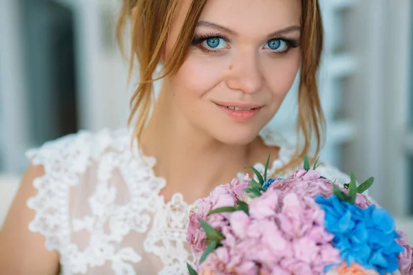 Retrato de cerca de una joven. Hermosos ojos azules miran directamente a la cámara. La novia con un look inolvidable disfruta del día de la boda . —  Fotos de Stock