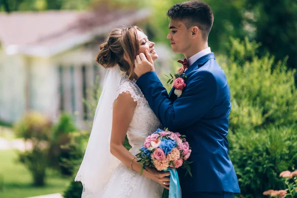 Człowiek starannie dostosowuje jego włosy do oblubienicy i patrzy na jej pięknie. Dziewczyna w sukni ślubnej przygląda się jej mąż i uśmiecha się. — Zdjęcie stockowe