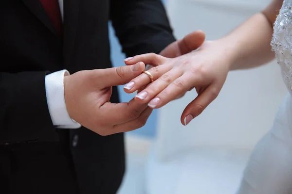 Primo piano delle mani di uomini e donne che si sposano. Un uomo indossa una fede nuziale su un dito snello e grazioso di una ragazza . — Foto Stock