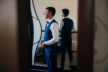 Nişanlısının kapıda bir çatlak aracılığıyla için gelin peeps. Bir adam onun odasında toplar, şık bir takım elbise koyar ve düğün için hazırlar.