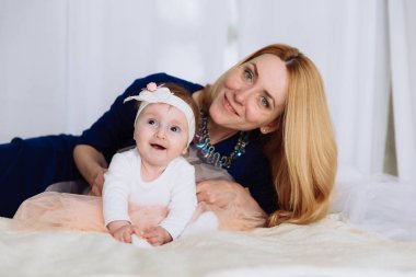 Sarışın yatakta, gülümseyerek ve kahverengi gözleri ve gülümsüyor benzeyen başında, küçük bir kız bir bandaj ile sarılma yalan söylüyor.