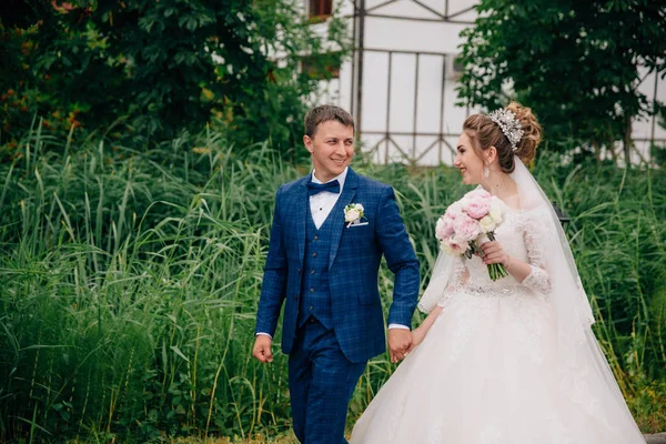 Efter bröllopet gick man och hustru en promenad i parken. Nygifta berätta för varandra historier och skratt. — Stockfoto