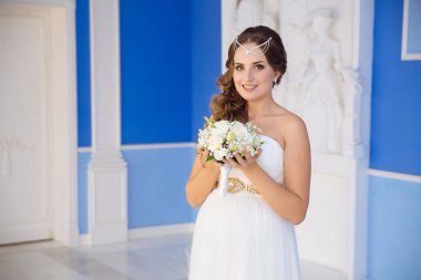 Bir genç kız siyah saçlı ve başında, boncuklar yapılmış süs giyinmiş bir gelinlik, tutar çiçekler ve gülümsüyor çünkü o bugün evleniyor.