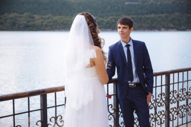 Gelin ve damat birbirlerine aşık nehrin arka planı itiraf ediyorum. Birkaç tutan eller, bir kız bir gelinlik ve peçe diyor ona bakar ve gülümser bir adam ne kadar sevdiğini.
