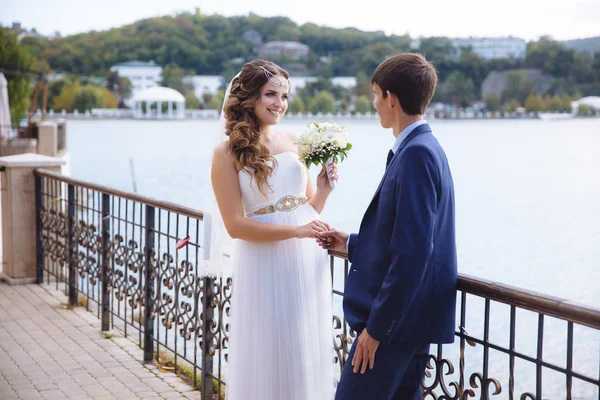 La novia y el novio jugaron una boda poco convencional en la orilla del río, donde solo había dos de ellos, la pareja se divierte y baila . — Foto de Stock