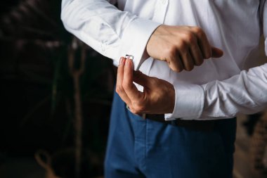 Yakın çekim eller kol düğmesi basılı tutun. Zarif beyefendi clother, beyaz gömlek ve siyah kuşak. Klasik iş elbiseleri ofiste, takı kavramı.