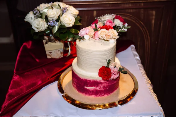上部には 花で飾られた連鎖ケーキ甘いからビューはテーブルの上です 背景の花束 結婚式での棒キャンディ — ストック写真