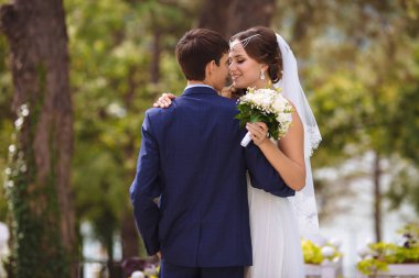 Gelin ve damat düğün günü yalnız geçirmek. Onlar kucaklamak ve yavaşça, eğleniyor öp parkta yürüyüş.