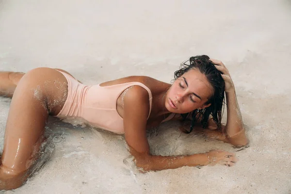 Porträtt av en vacker flicka med en sexig kropp på stranden med vit sand. Ung kvinna i baddräkt sola på en semester utomlands. Charmig modell på en öde ö. — Stockfoto