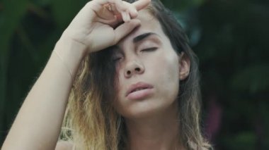 Avrupalı genç bir bayan bir yakın çekim ağır çekim çekim yavaşça onun burun ve dudak, utanç verici yüzünü ferns uzak önde gelen dokunmadan onun yüzüne tırnağının ucuna kadar tutar.