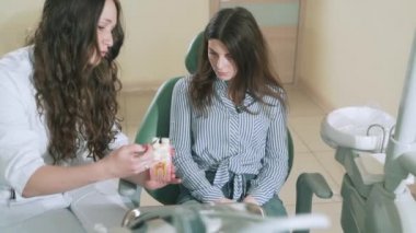 Yavaş yavaş steadikam diş hekimi Doktor açıkça çekim hastanın çürük, nedenini açıklar kukla manken, doktorlar ofiste kız korkmuş ve iftiralar kukla üzerinde tiksinti olduğunu gösterir