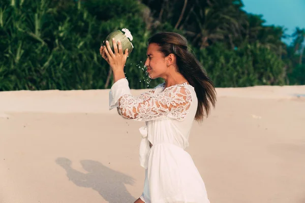 El concepto de expectativa, realidad. Una joven quería beber bellamente agua de coco, pero ridículamente derramó una cara. Primer plano de una chica en la playa bebiendo jugo de coco . — Foto de Stock