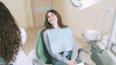 Yavaş yavaş korkusuz bir sandalye ve gülümser office oturur diş hekimleri hastada gülümseyen steadicam silah, doktor diş bir ayna ve bir çift taraflı mala ile ağız boşluğu inceliyor