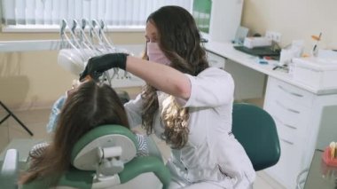 Ağır çekim çekim Kadın dişçi Diş dolgu malzemesi kuvvetlendirmek için aygıt photopolymerizer çalışır. Diş Hekimliği, diş tedavisi, sağlık, güzellik için aygıt kavramı