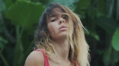 Sexy çekici genç kız çerçeve poz, vahşi kediler seyir scrutinizing. Ağır çekim çekim yakın çekim yeşil bir arka plan üzerinde kısa kıvırcık ile bir modelinin.