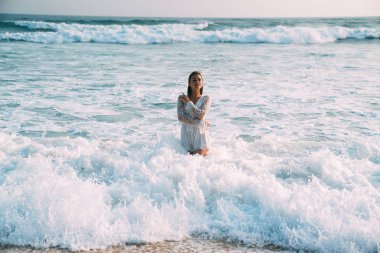 Esmer güzel bir takım elbise içinde bel-derin deniz suyu ve beyaz köpük olduğunu. Denizde yüzme gevşeme, plaj, kavramı güneşlenme, insanlar.