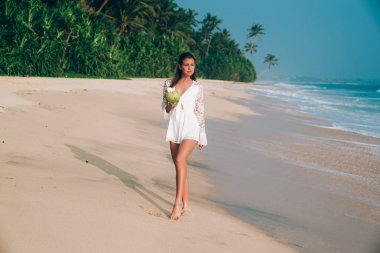 Güzel bir esmer beyaz plaj Tulum içinde deniz kıyısı yürüyor, beyaz kumlu plaj hayran, şık giysiler giyiyor. Boş zaman, seyahat, insanlar kavramı.