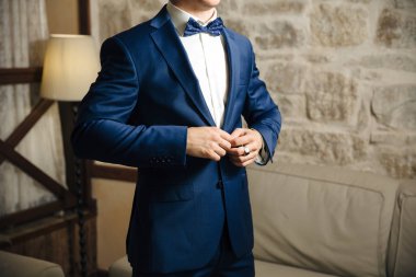 Close-up kadar tasarımcı onarım ile şık bir ofiste ayakta ceketinin düğmelerini bir iş şık adamı kırpılmış bir çerçeve.