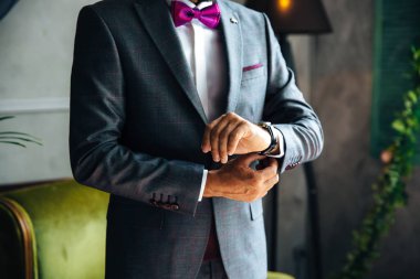 Şık bir işadamı kırpılmış bir çerçeve bugün evleniyor, şık bir takım elbiseyi giy, beyaz bir gömlek giyer ve şık pahalı deri saatleri, kol düğmeleri onun kol bağlar yıkık planıdır