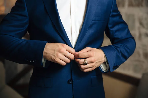 Primer plano de un marco recortado de un hombre elegante de negocios abotonando su chaqueta, de pie en una oficina elegante con reparación de diseño . —  Fotos de Stock
