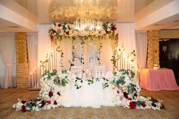 Begreppet en bröllopsfest, firande av älskare, inredning, blommor, tyger. Tabellen för nygifta är dekorerad med blommor, ljus och tyger. — Stockfoto