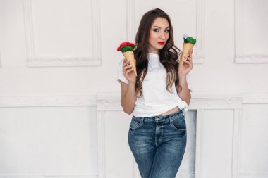 Olağandışı nesneleri çiçekler gözleme bardaklarda dekor, kırmızı parlak dudaklar ile şık giysiler içinde güzel bir esmer kız inceliyor.