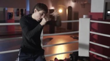 Yakın çekim ağır silah, boks salonunda genç boksör trenler çekim tekniği yumruklar eldiven olmadan pratik ringde taşır. Spor, eğitim, boks, insanlar, erkekler kavramı.