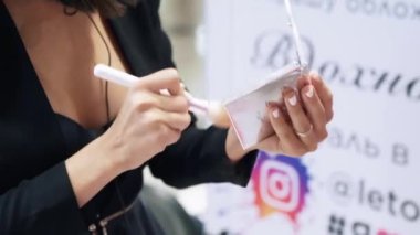 Kırpılmış çerçeve makyöz makyaj, yapıyor Close-up büyük bir fırça üzerinde toz tutar, bu sprey ve istemciler yüze getiriyor. Güzellik, makyaj, güzellik salonları, stilistler kavramı