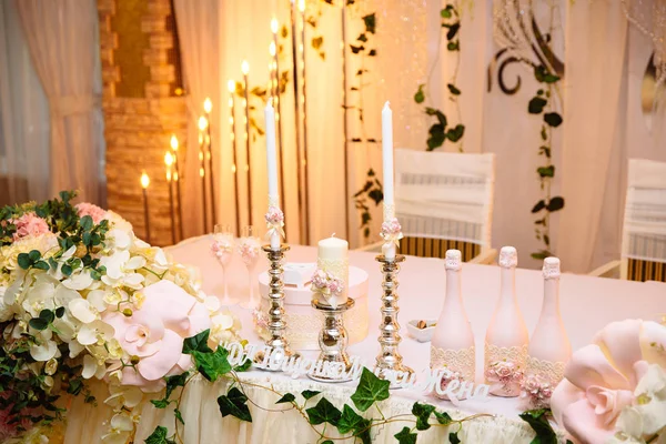 The concept of a wedding celebration, celebration of lovers, decor, flowers, fabrics. The table of the newlyweds is decorated with flowers, candles and fabrics. — Stock Photo, Image