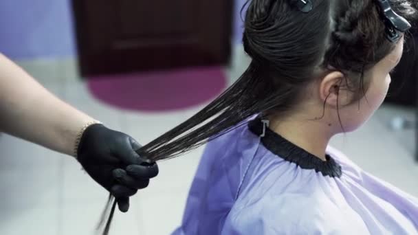 Le coiffeur peigne les cheveux mouillés des clients après application de kératine, répartit la composition sur toute la longueur des cheveux avec un peigne. Gros plan ralenti — Video