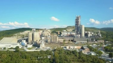 Havadan görünümü çimento fabrikası, büyük sanayi dağlarda bina. Sarnıçlar, borular, metal yapılar, beton üretim kavramı. Güzel bir mavi gökyüzü ile gündüz görüntüleri.