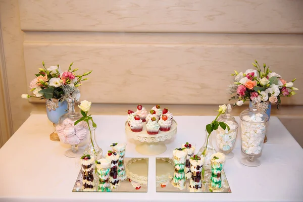 Vista superior da barra de doces, uma mesa com doces e sobremesas na mesa. Buffet com deliciosos cupcakes, bolos, biscoitos, flores . — Fotografia de Stock