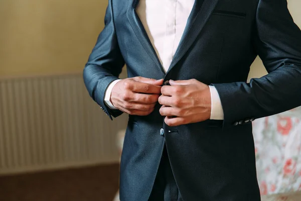 Gros plan d'un cadre recadré d'un homme d'affaires élégant boutonnant sa veste, debout dans un bureau élégant avec réparation designer . — Photo