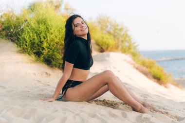 Mutlu genç bir öğrenci, geldi dinlenmek için onun şık mayo bir beyaz kumlu plajda güneşlenirken, yaz zevk. Seyahat, eğlence, insanlar kavramı. Boşaltmak mayo üzerinde.