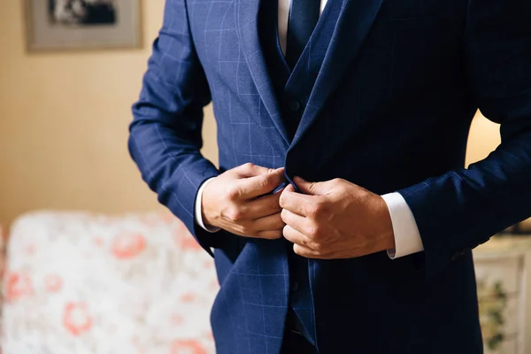 Primer plano de un marco recortado de un hombre elegante de negocios abotonando su chaqueta, de pie en una oficina elegante con reparación de diseño . — Foto de Stock