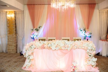 Bir düğün kutlama, aşık, dekorasyon, çiçek, kumaş kutlama kavramı. Yeni evliler tablo çiçekler, mumlar ve kumaşlar ile dekore edilmiştir.